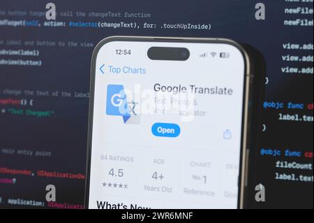 New York, USA - 23 febbraio 2024: Google Translate su schermo iphone in background di programmazione codice sfocato Foto Stock