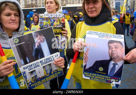 Bucarest, Romania. 11 marzo 2024. Operatori sanitari, con manifesti con i ritratti del primo ministro Marcel Ciolacu e del ministro della salute Alexandru Rafila, unionista della Federazione rumena di solidarietà sanitaria, protesta davanti alla sede del governo rumeno insoddisfatto degli aumenti salariali ricevuti annunciando che, se le loro richieste non sono soddisfatte, potrebbe essere l'ultima manifestazione fino allo sciopero generale. Lucian Alecu/Alamy Live News Foto Stock