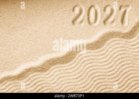 Impronte di numeri 2027 Capodanno su sfondo di onde di sabbia dorata Foto Stock