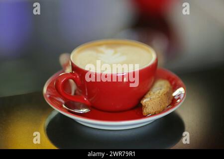 Symbolbild zum Thema Kaffee Hier: Rote Kaffeetasse mit Cappucino *** immagine simbolica sul tema del caffè qui tazza di caffè rosso con cappuccino Foto Stock