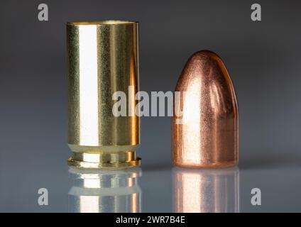 Shell proiettile smontato impostato su sfondo grigio scuro primo piano riflesso Foto Stock