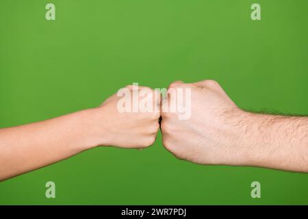 Foto di due persone mani palmi che toccano pugni che mostrano situazioni di conflitto sfondo di colore verde isolato Foto Stock