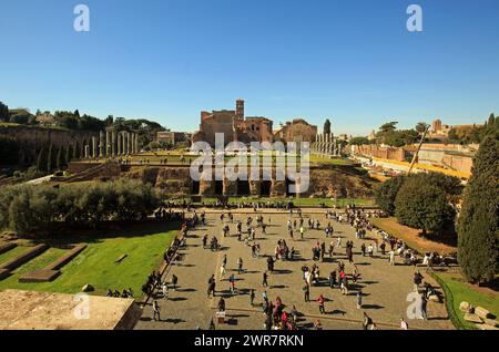 Vista dal Colosseo sul Colle Palatino, con molti turisti che camminano per Roma, Italia Foto Stock