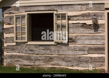 Titolo: Finestra aperta con persiane sulla parete esterna della capanna in legno originale tronchi quadrati di vecchio fienile storico ravvicinato di legno e forma orizzontale a fessura Foto Stock