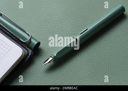Penna stilografica e sfondo in pelle verde per notebook Foto Stock