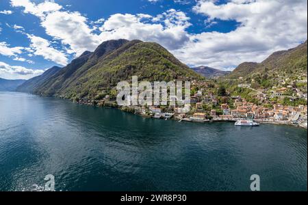 Veduta aerea di Argegno, idilliaco villaggio sul Lago di Como, Lombardia, Italia. Imbarco dei passeggeri in traghetto in attesa di partire Foto Stock