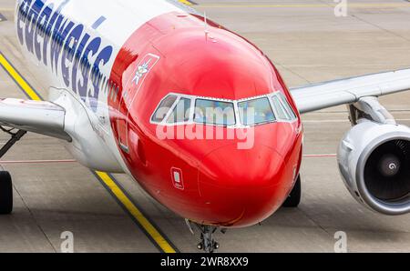 Flugpassagiere steigen aus dem Airbus A320-214 von Edelweiss Air aus. DAS Flugzeug ist nach der Landung an einem Fingerdok des Terminal B geparkt. Reg Foto Stock