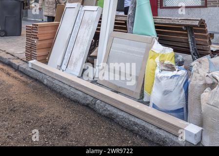 Un mucchio di materiali da costruzione e spranghe in legno nel mezzo della strada Foto Stock