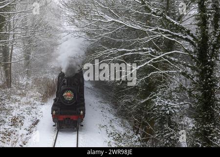 03/12/2023 lo speciale natalizio della Ecclesbourne Valley Railway, «Babbo Natale Enchanted Journey», fuma attraverso boschi innevati vicino a Wirksworth, dopo aver superato i primi anni Foto Stock