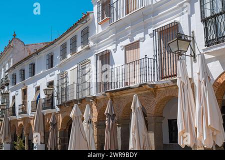 Due ombrelloni bianchi su un patio di fronte agli edifici Foto Stock