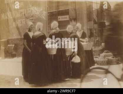 Donne in costumi tradizionali con cestini, in piedi per strada, questa foto fa parte di un album., G. Hidderley, Paesi Bassi, 1920 - 1940, supporto fotografico, altezza 73 mm x larghezza 99 mm, fotografia Foto Stock