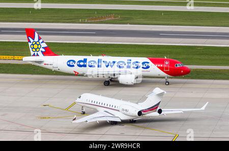 Ein Airbus A320-214 von Edelweiss Air rollt auf dem Flughafen Zürich zur Startbahn. Registrazione HB-IHY. Davor steht ein Bombardier Global 6500 von ne Foto Stock