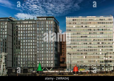 Moderni edifici per uffici con facciate in vetro riflettente sotto un cielo blu con nuvole sparse a Liverpool, Regno Unito. Foto Stock