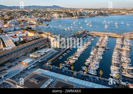 Vista su Cascais, città costiera, porticciolo vicino a Lisbona nelle soleggiate serate estive, punto di vista su droni. Le acque dell'Oceano Atlantico, la costa rocciosa, le barche a vela, gli yacht, i catamarani ormeggiati dai jet, il sole basso, il lusso e il tempo libero. Foto Stock