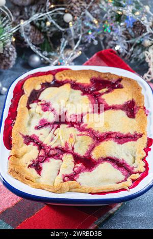 Delizioso ciabattino con frutti di bosco in teglia smaltata, decorazione natalizia su sfondo, verticale Foto Stock