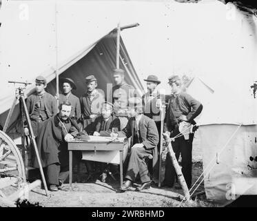 Yorktown, Virginia, nelle vicinanze. Ingegneri topografici, Camp Winfield Scott, foto mostra un gruppo di nove uomini in posa davanti a una tenda con uno strumento di rilevamento a sinistra. I due uomini seduti al centro e a destra sono probabilmente Frederick W. Door e John W. Donn. L'ufficiale seduto a sinistra è William H. Paine che inventò la bobina di acciaio indossata dall'uomo in piedi a destra. Secondo da destra sembra essere Allan Pinkerton., fotografia dal principale teatro di guerra orientale, la campagna peninsulare, maggio-agosto 1862., Gibson, James F., 1828-, fotografo, 1862 maggio 2. Foto Stock