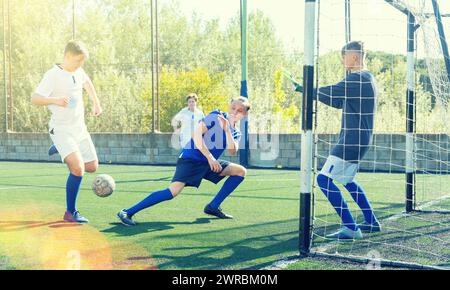 Giovani giocatori di calcio che lottano per la palla Foto Stock