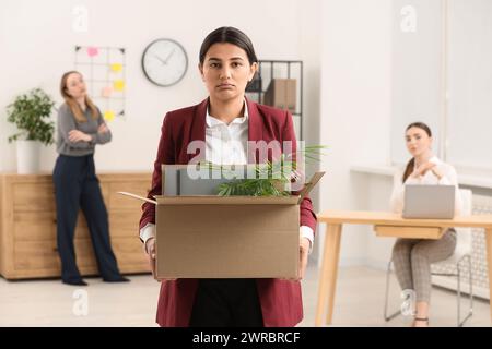 Problema di disoccupazione. Donna con scatola di effetti personali in ufficio Foto Stock