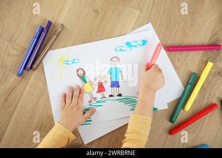 Bambina che disegna con un pennarello sul pavimento, vista dall'alto. Arte dei bambini Foto Stock