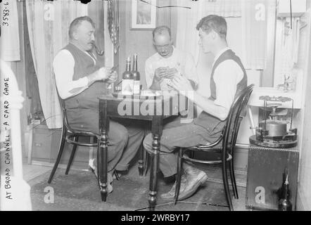 A Broad Channel - un gioco di carte, la fotografia mostra gli uomini che giocano a carte accanto a una stufa a primus in una casa a Broad Channel, Queens, New York City. 1910 e ca. 1915, Glass negative, 1 negativo: Glass Foto Stock