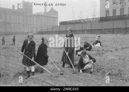 Giardino Rockefeller, la fotografia mostra i bambini che curano il terreno in un Rockefeller Garden nella sua nuova posizione in 65th Street e Avenue A nel maggio 1917. La National Plant, Flower and Fruit Guild curava il giardino donato dalla Rockefeller Foundation. Grande edificio con il cartello 'Central Brewing Co.' sullo sfondo., 1917 maggio, Glass negative, 1 negativo: Glass Foto Stock