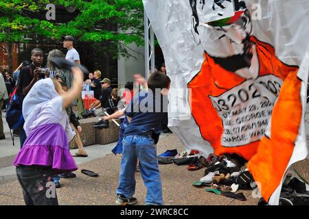 Toronto, Ontario, Canada - 29/05/2009: Bambini che lanciano scarpe allo striscione di George Bush - presidente degli Stati Uniti alla manifestazione di pace a Toronto, Ont Foto Stock