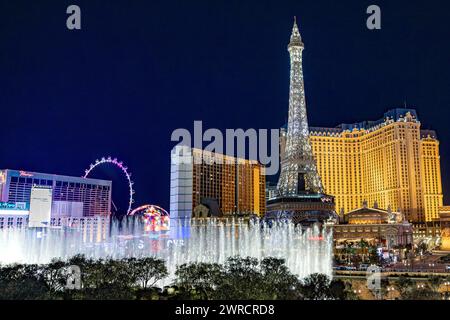 Las Vegas Boulevard strip fontane Bellagio / casinò di Parigi di notte 2024 - luci della città cartelli colorati e attrazioni turistiche sfera e High Roller Foto Stock