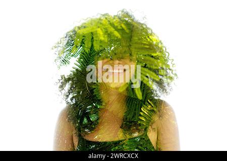 Un ritratto a doppia esposizione di una donna sorridente unita alla felce verde Foto Stock