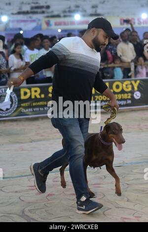 Cani che eseguono allenatori durante l'Agartala Dog Carnival-2024, organizzato dalla Tripura Veterinary Doctors Association & Pawsome (Un'organizzazione sociale) ad Agartala. Tripura, India. Foto Stock