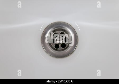 Scolare in un lavello in ceramica bianca. Sfondo Foto Stock
