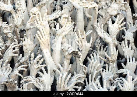 Chiang Rai, Thailandia - dicembre 2022: Mani famose dall'arte infernale sul territorio del Tempio bianco Wat Rong Khun molte statue Foto Stock