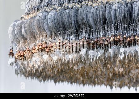 Chiang Rai, Thailandia - dicembre 2022: Dettaglio di un albero come un appendiabiti dove i fedeli appendono foglie di metallo argentato decorate dove scrivere desideri e pensieri Foto Stock