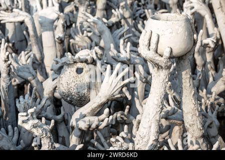 Chiang Rai, Thailandia - dicembre 2022: Mani dall'inferno sul territorio del Tempio bianco Wat Rong Khun molte statue Foto Stock