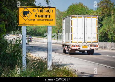 Cartello metallo strada attenzione elefanti attraversamento testo attenzione elefante attraversamento campagna Thailandia giorno di sole Foto Stock
