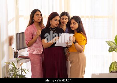 Gruppo di colleghi aziendali che esaminano i documenti durante una riunione in un ufficio moderno Foto Stock