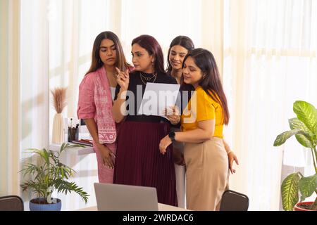 Gruppo di colleghi aziendali che esaminano i documenti durante una riunione in un ufficio moderno Foto Stock