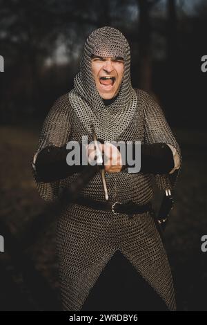 Fanteria medievale uomo armato vestito con armatura a catena all'aperto Foto Stock