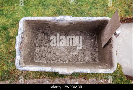 Calcestruzzo misto in secchio, lavori di costruzione in giardino Foto Stock