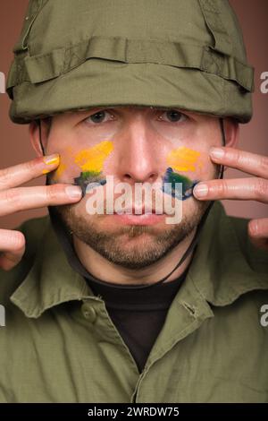 Uomo che esprime rispetto per l’Ucraina con colori nazionali sul viso Foto Stock