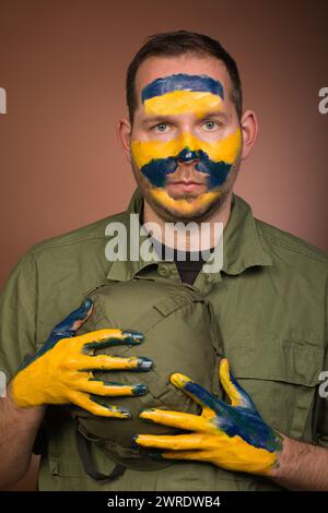 Uomo che esprime rispetto per l’Ucraina con colori nazionali sul viso Foto Stock