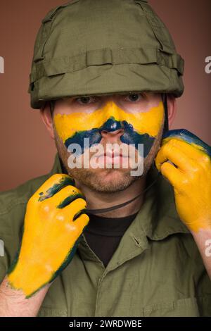 Uomo che esprime rispetto per l’Ucraina con colori nazionali sul viso Foto Stock