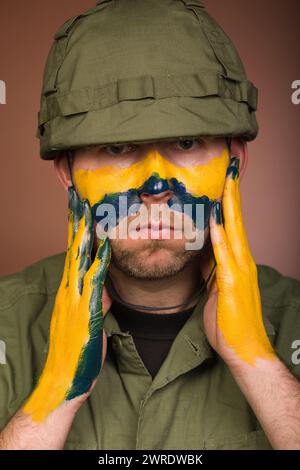 Uomo che esprime rispetto per l’Ucraina con colori nazionali sul viso Foto Stock