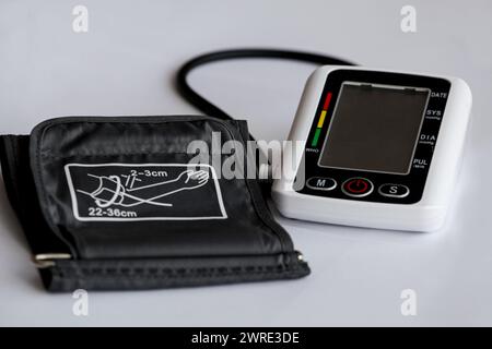 Dispositivo di misurazione della pressione sanguigna, tonometro su sfondo medico bianco. Tonometro elettronico digitale. Mal di testa, trattamento dell'ipertensione e. Foto Stock