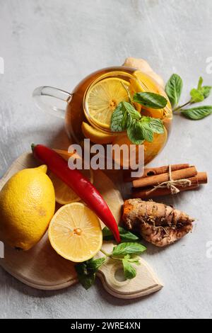 Tè alle erbe con menta, zenzero, limone e spezie su fondo testurizzato con spazio di copia. Concetto di medicina casalinga. Bevanda biologica naturale per il periodo freddo Foto Stock