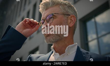 Primo piano ritratto in città all'aperto sorridente felice maturo uomo d'affari anziano dirigente d'affari senior spensierato CEO di società di mezza età in contatto Foto Stock