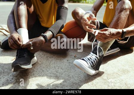 Uomini neri che indossano scarpe sportive per giocare allo streetball Foto Stock