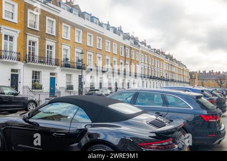 LONDRA - 11 GENNAIO 2024: Strada di eleganti case a schiera di stucchi bianchi nell'area SW3 di Kensington e Chelse Foto Stock