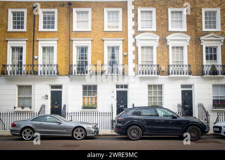 LONDRA - 11 GENNAIO 2024: Strada di eleganti case a schiera di stucchi bianchi nell'area SW3 di Kensington e Chelse Foto Stock