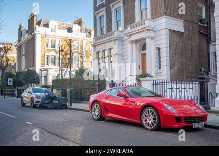 LONDRA - 15 GENNAIO 2024: Ferrari rossa parcheggiata in una strada esclusiva di case di lusso a Kensington Foto Stock