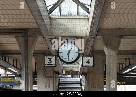 Londra, Regno Unito - 27 febbraio 2024 - 13:31 sull'orologio della stazione e gli indicatori numero 3 e 4 della stazione Acton Town. Trasporto di viaggio, SP Foto Stock